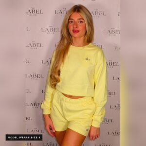 Model wearing the Alo jumper and shorts set in yellow, size small