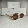 Gold-tone oval sunglasses with brown gradient lens, angled view