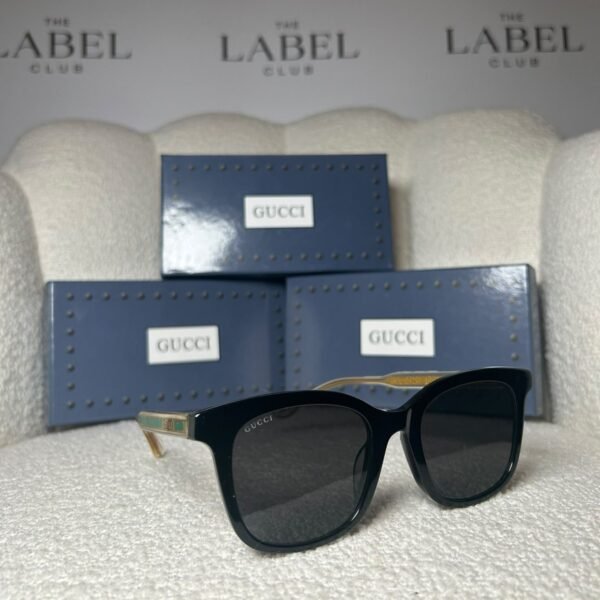 Black oversized square sunglasses, angled view showing the clear temple