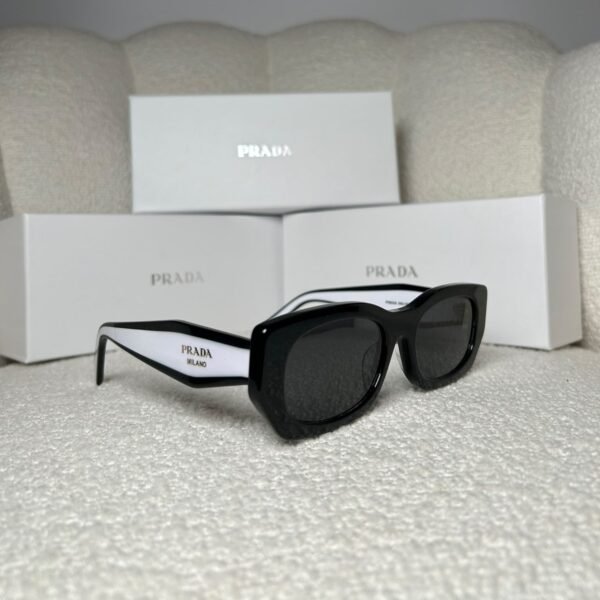 Black rectangular sunglasses with white inner temples, angled view