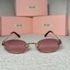 Gold rimless oval sunglasses with rose-pink lenses